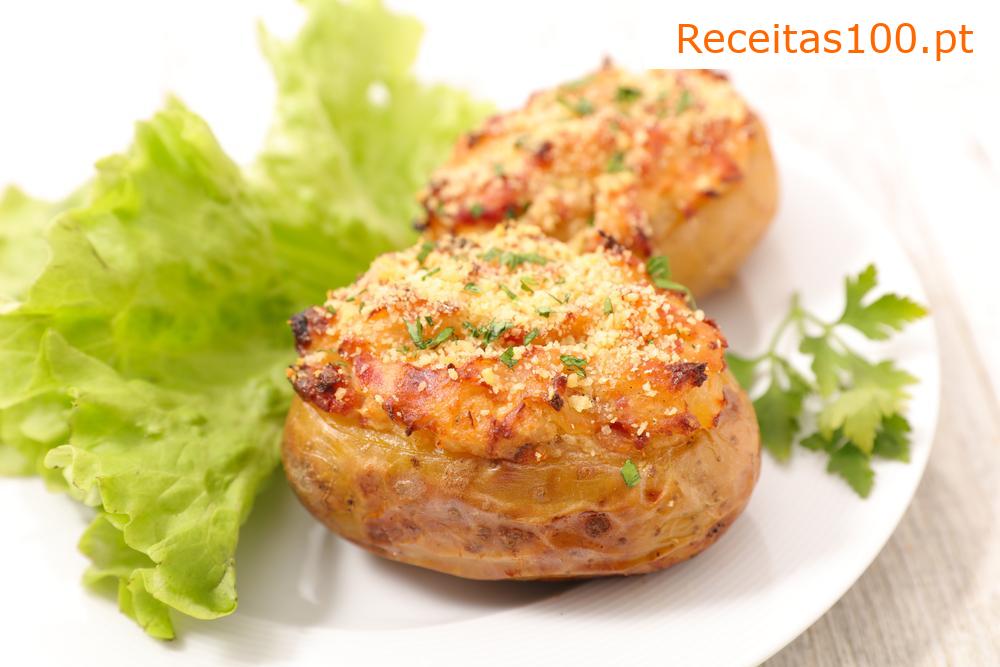 Batatas assadas com queijo, alho-poró, presunto e carne de porco.
